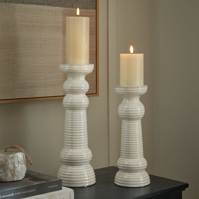 Sile candle holders with lit pillar candles on a dark sideboard, shown with the large size sold separately