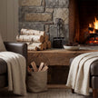 Hearth tidy set on a stone hearth beside a lit fire