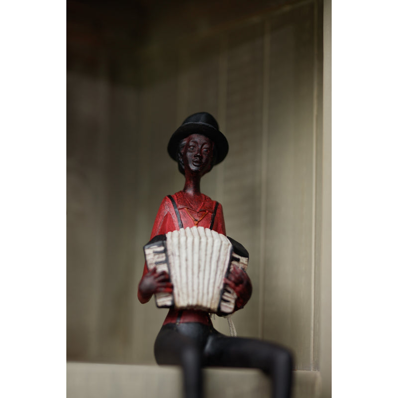 Accordion player figurine sitting on a shelf