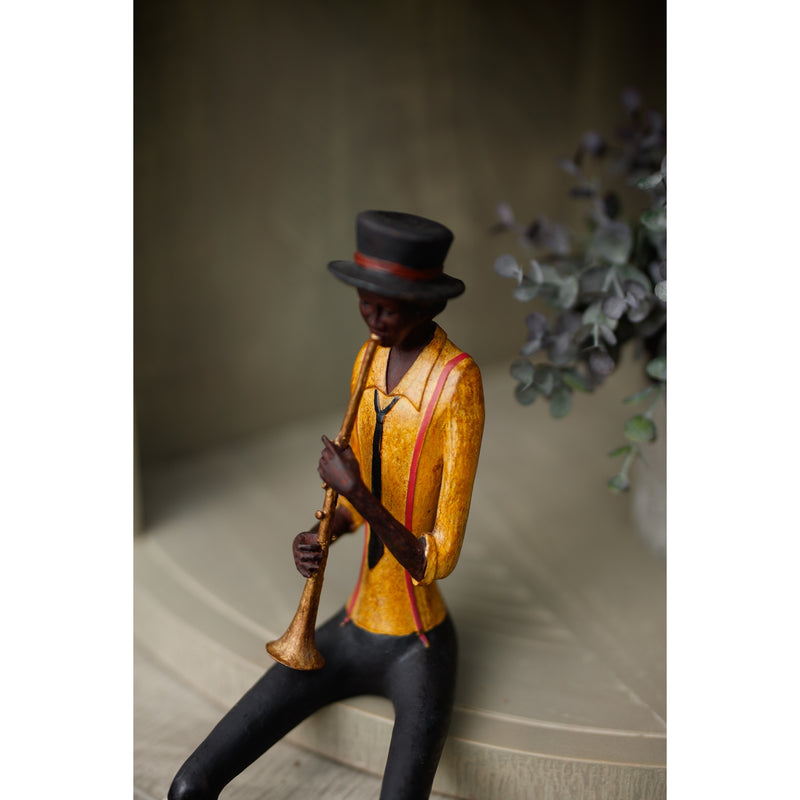 Close-up of the trumpeter figurine on a shelf