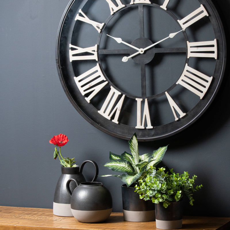 Metallic grey planters with greenery on a shelf below a wall clock, other items sold separately