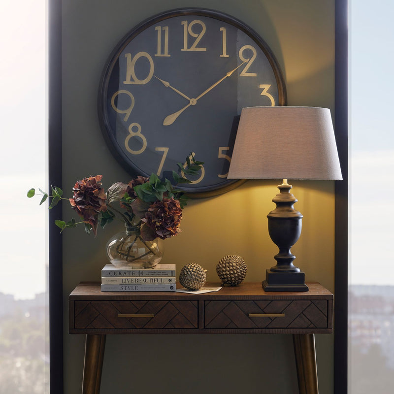 Soho black and brass clock above a console table with a lamp