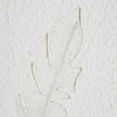 Close-up of a raised white feather on textured background