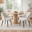 Sorelle cream chairs around a round wooden dining table