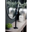 Jazz trumpeter figurine on a console table beside silver vases