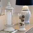 Stone hurricane lantern filled with decorative balls on a sideboard, shown with other items sold separately