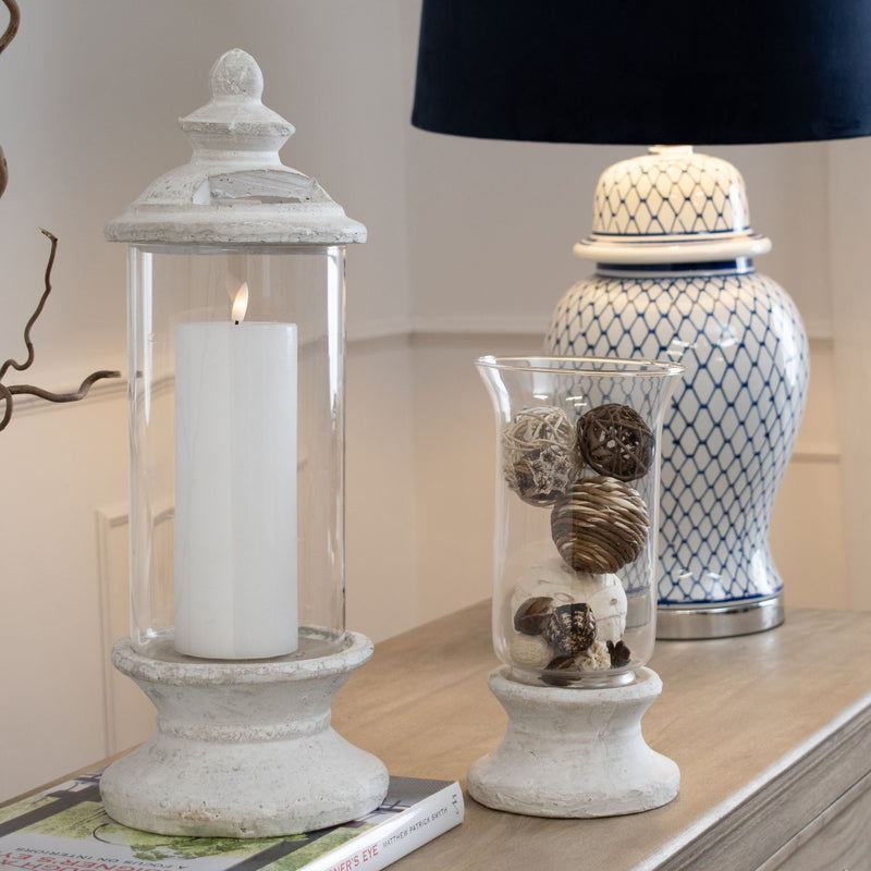 Stone hurricane lantern filled with decorative balls on a sideboard, shown with other items sold separately