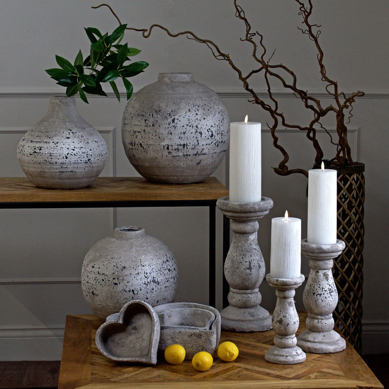 Stone-effect candle holders with LED candles beside speckled vases, shown with other sizes sold separately