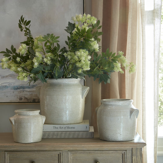 Tarn pots with flowers on a sideboard, shown with other sizes sold separately