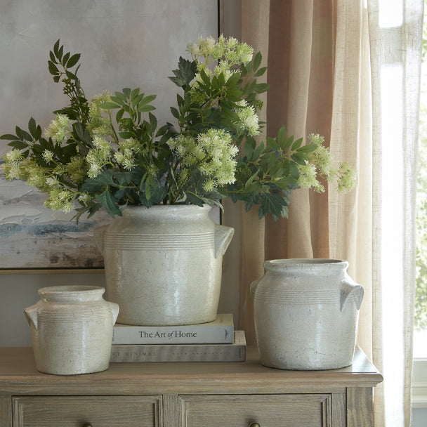 Tarn pots with flowers on a sideboard, shown with other sizes sold separately