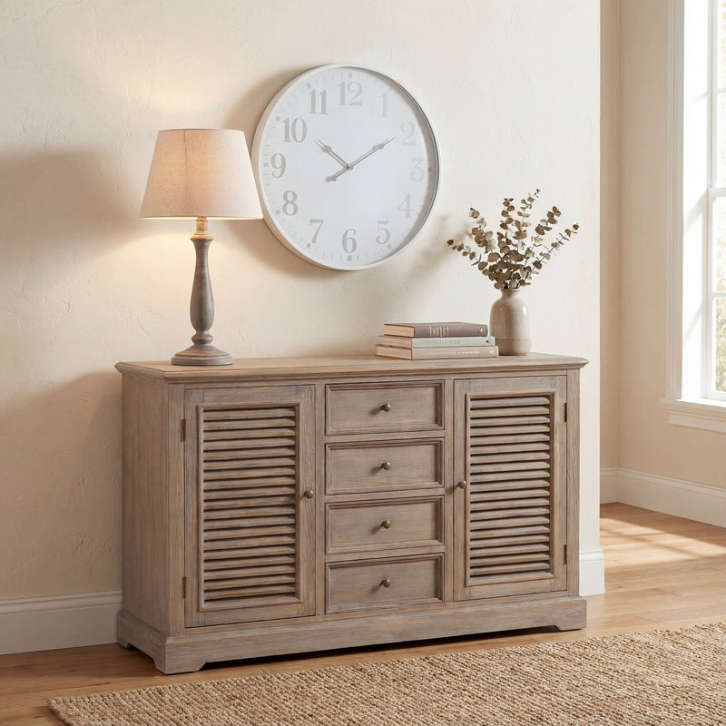 Teos lamp on a louvred sideboard beneath a large wall clock