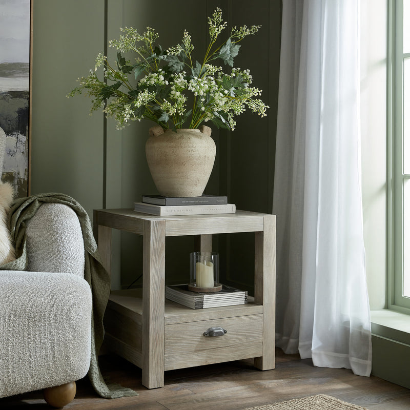 Terra urn vase with greenery on a side table