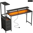 Black gaming desk with RGB lights, charging station, monitor stand and PC stand