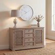 Uthina lamp on a louvred sideboard beneath a large wall clock