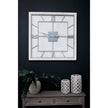White square clock on a dark wall above a sideboard