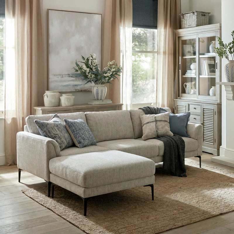Zephra sofa and footstool in a living room with blue cushions and a jute rug
